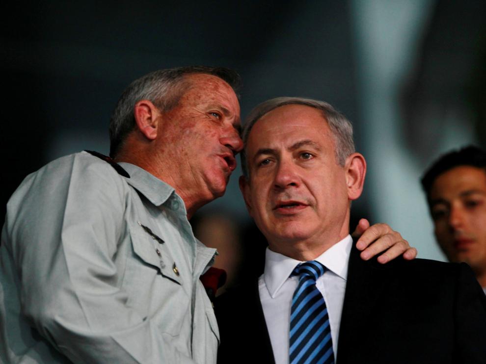 Benny Gantz (i) y Benyamin Netanyahu (d) conversando durante la ceremonia.