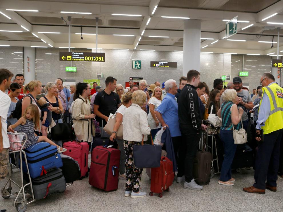 Largas filas de pasajeros y clientes de la agencia de viajes Thomas Cook en el aeropuerto de Mallorca tras el cierre de la compañía.