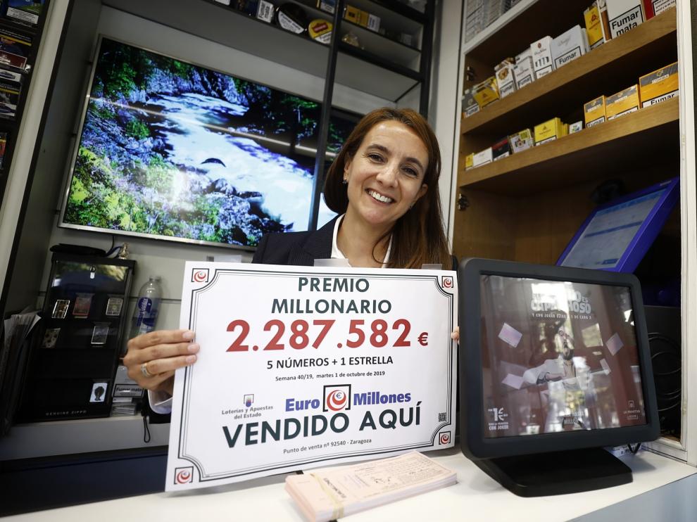 Ana Isabel Nuin, responsable de la administración, sostiene el cartel anunciador del premio millonario.