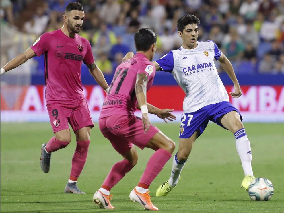 Quique Clemente, con el balón ante Renato y Sadiku este jueves en el partido ante el Málaga en La Romareda.