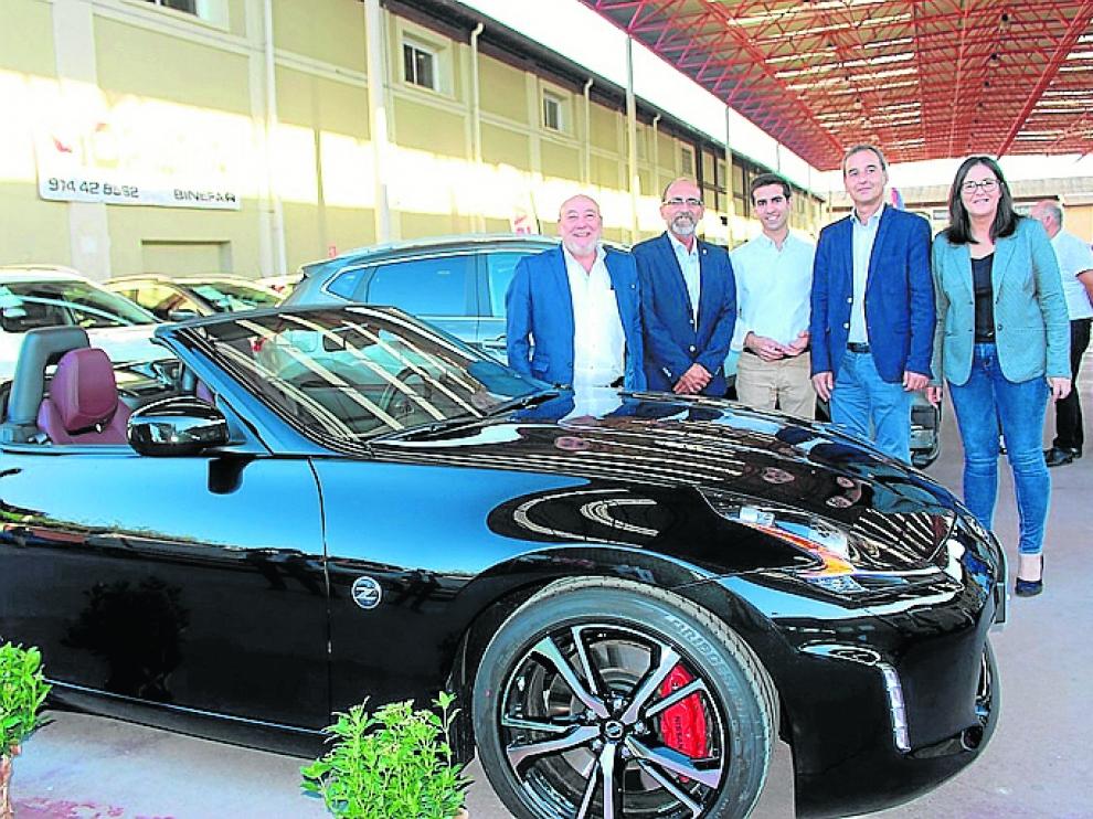 Las autoridades, junto a uno de los coches a la venta.