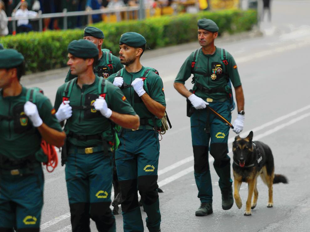 El cabo Sergio Ona, al final del grupo, con la cruz al mérito ya colgada, desfilando este domingo junto a los compañeros del Servicio de Montaña y llevando al perro de rescate Arnold.