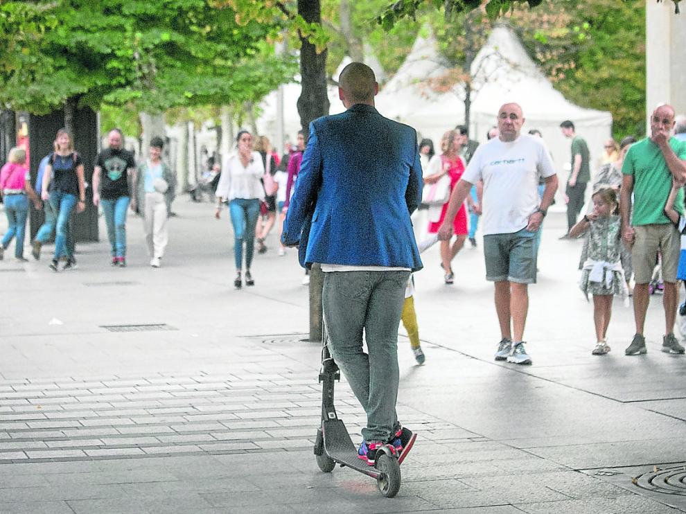 Un usuario de patinete circula de forma irregular por la acera de la plaza de Aragón.