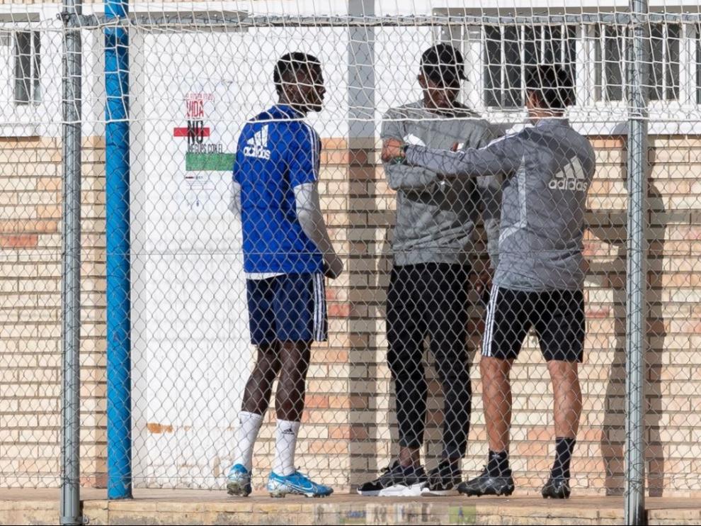 Dwamena, en el centro de la fotografía, con gorra negra y vestido de calle, charla con Bikoro y un auxiliar del Real Zaragoza en la mañana de este miércoles en la Ciudad Deportiva.
