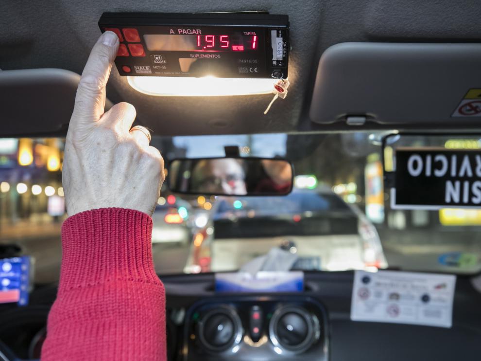 Un taxista activa un contador en el interior de su vehículo.