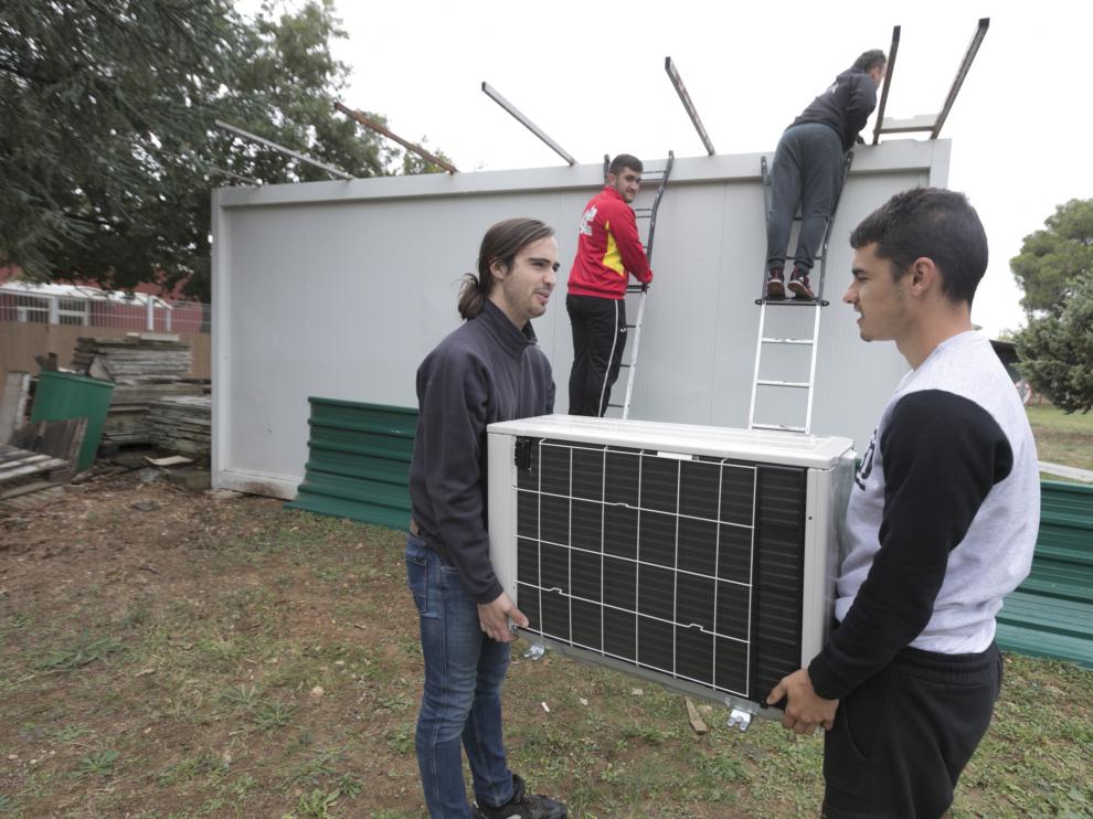 Alumnos del centro de FP Pirámide de Huesca, el pasado viernes, instalan equipos de climatización en el aula de experimentación.