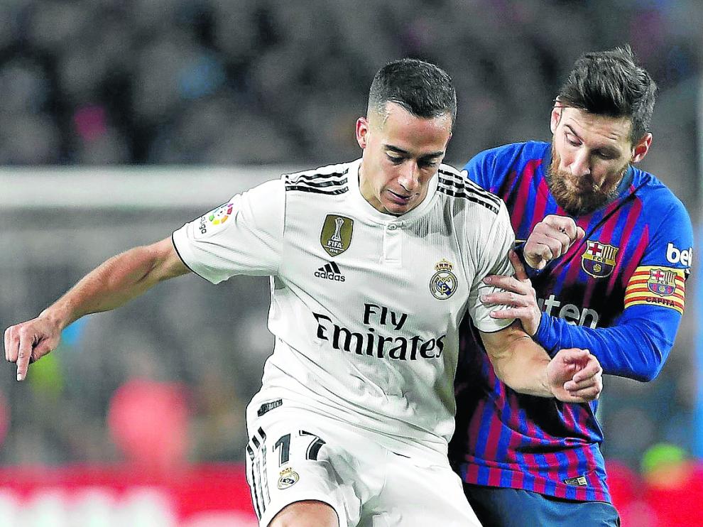 El madridista Lucas Vázquez es presionado por el jugador del Barcelona Leo Messi.