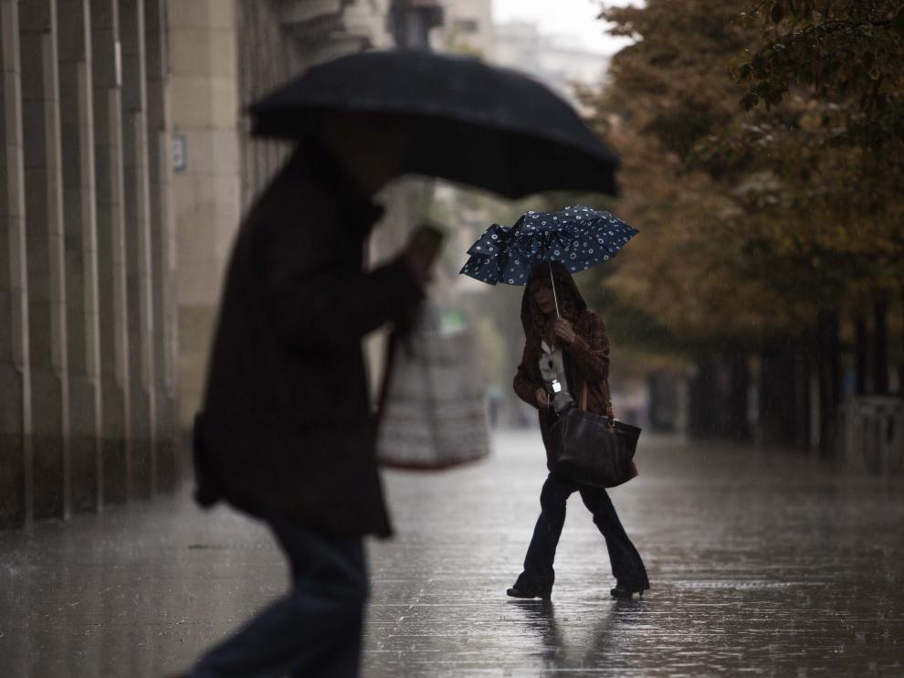 Dos personas se protegen de la lluvia en Zaragoza