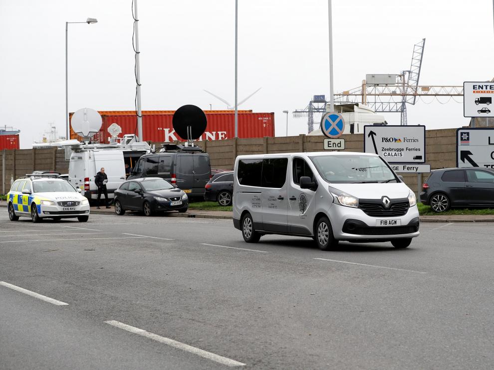 Un furgón fúnebre abandona el puerto de Tilbury escoltado por la Policía.