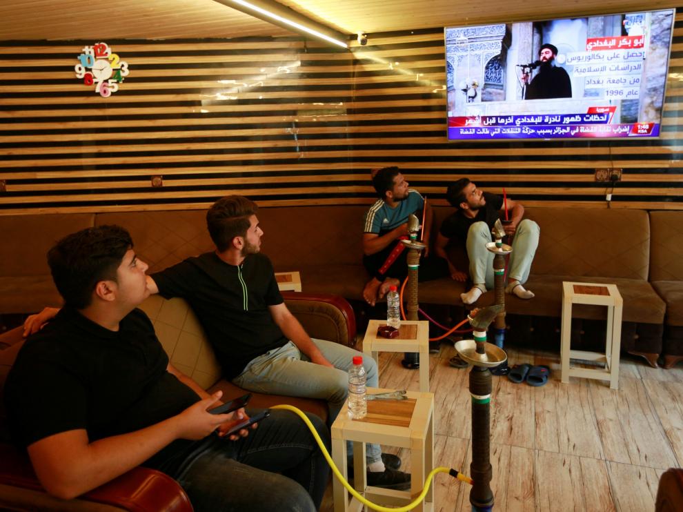 Jóvenes iraquíes siguen por televisión la noticia de la muerte de Al Bagdadi.