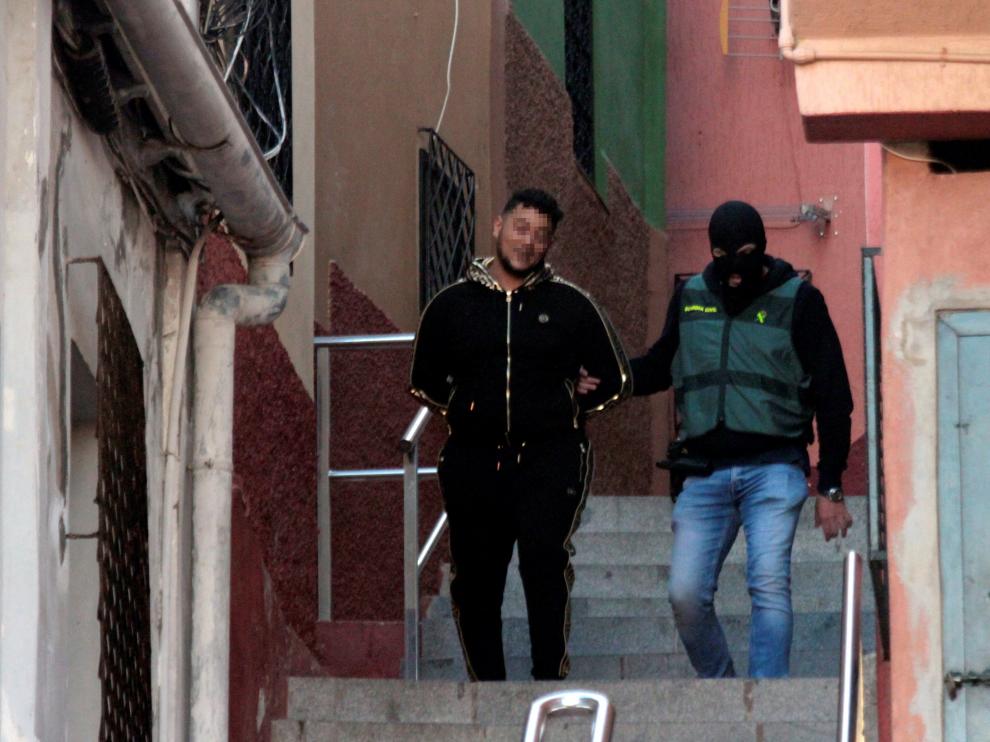 Un miembro de la Guardia Civil con uno de los detenidos durante la operación contra el tráfico de drogas y de inmigrantes que se ha iniciado en Ceuta y que se extiende a otras localidades, como Algeciras y Málaga.