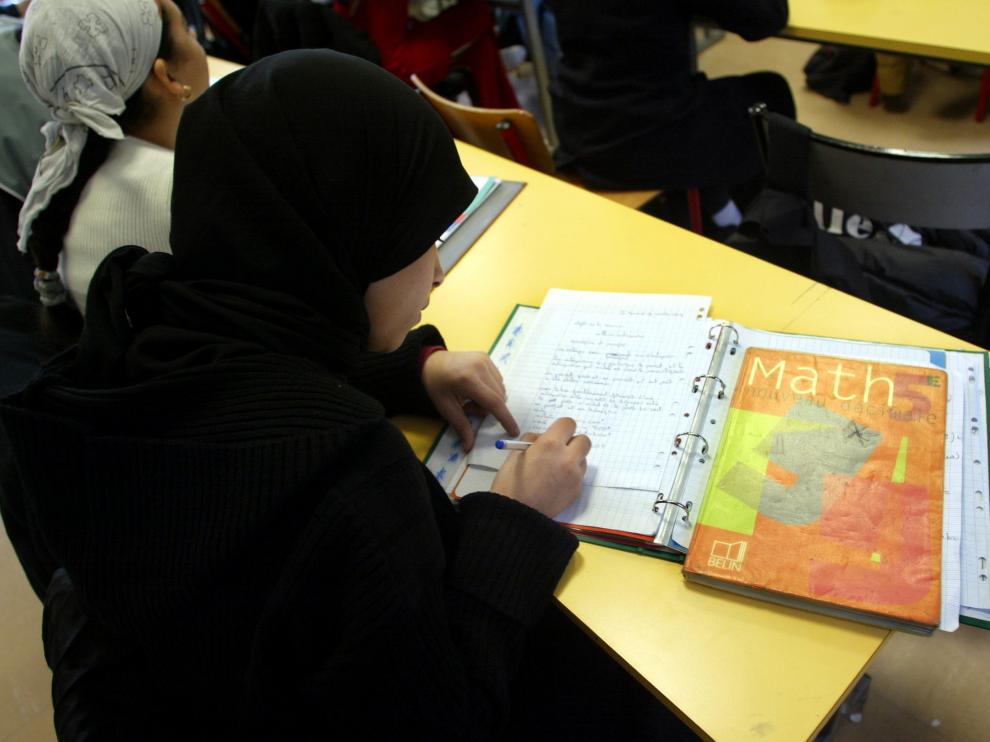 Schoolgirls with Islamic headscarves study in the private catholic school of Saint Mauront in Marseille January 14, 2004. French government planned to submit to parliament a draft law banning religious symbols such as Islamic headscarves in state schools, despite protest from Muslims in France and around the world. REUTERS/Jean-Paul Pelissier FRANCE