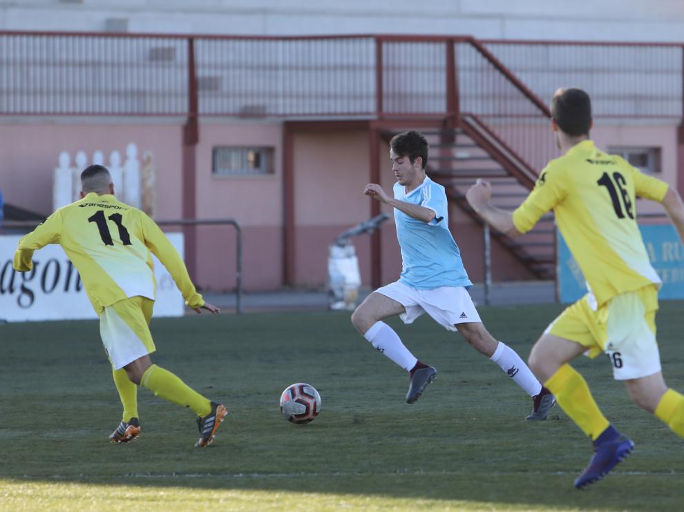 Un jugador del Cella conduce el balón ante la presión de dos defensores.