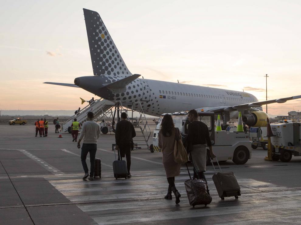 Varios viajeros se dirigen a un avión en el aeropuerto de Zaragoza.
