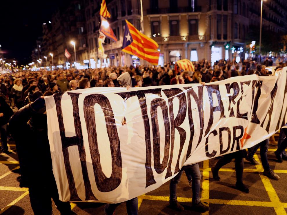 Un grupo de CDR enmascarados tras la pancarta que reza "lo volveremos a hacer".