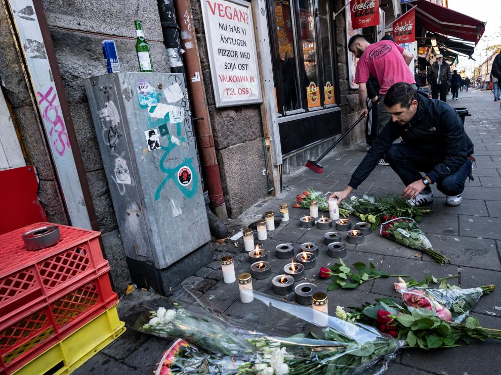 Un hombre coloca una vela en el lugar en el que el joven de 15 años fue asesinado en la ciudad sueca de Malmö.