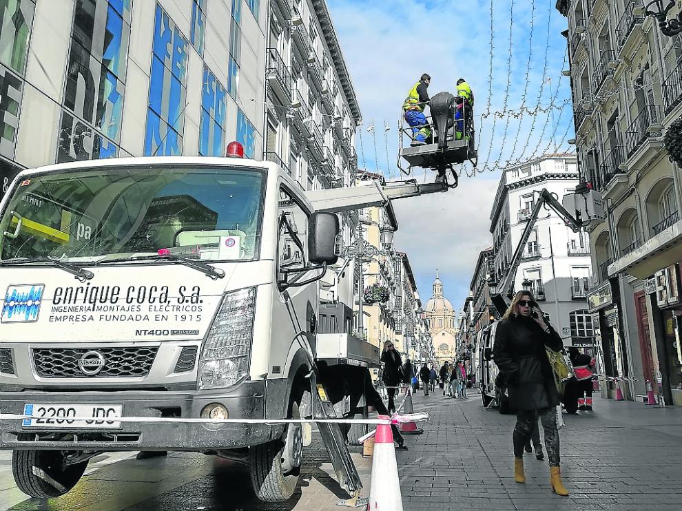 Los operarios ultiman la instalación de las luces de Navidad en la calle de Alfonso I.
