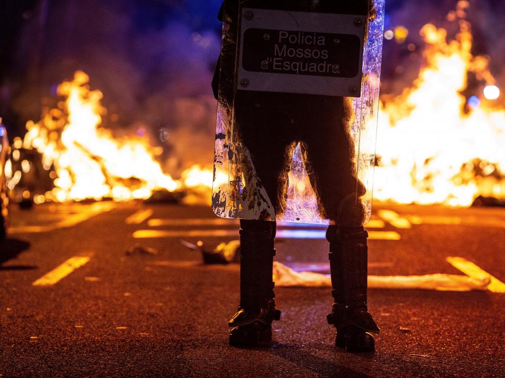 Un mosso ante un acto vandálico de los CDR en una calle de Barcelona