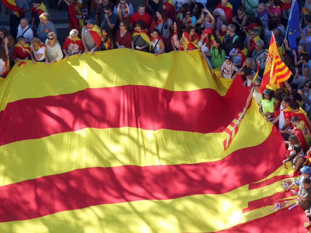 Una gran bandera cuatribarrada desplegada en el centro de Barcelona.