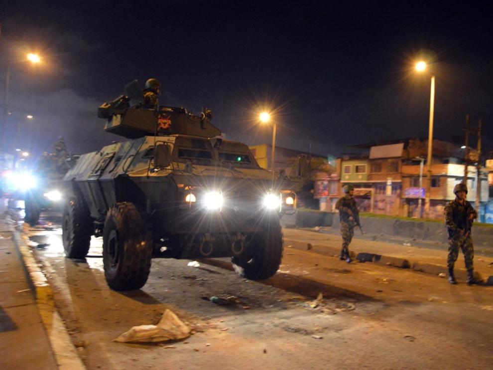 Militares en un tanque y a pie patrullan por las calles de un barrio de Bogotá como se puede ver en esta foto cedida por el Ejército de este país.