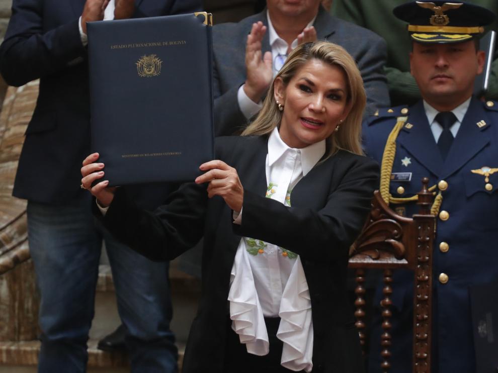 La presidenta interina de Bolivia, Jeanine Áñez, sostiene un documento durante la promulgación de una ley de urgencia este domingo en La Paz