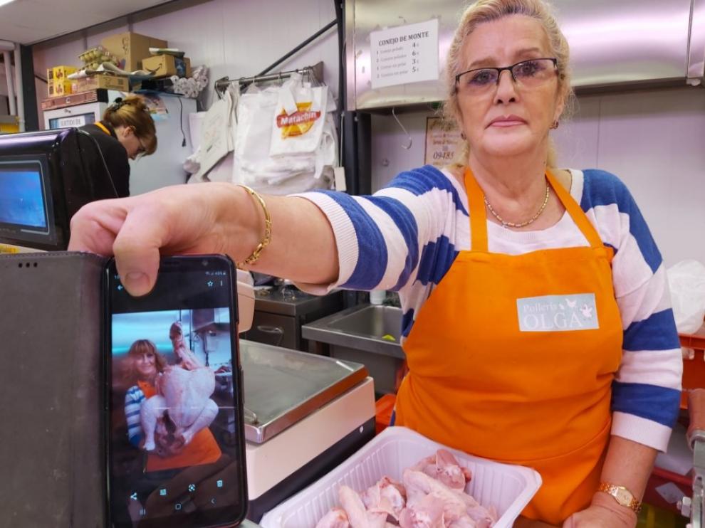 Olga Romeo enseña uno de los enormes pavos que han vendido en su puesto del mercado.