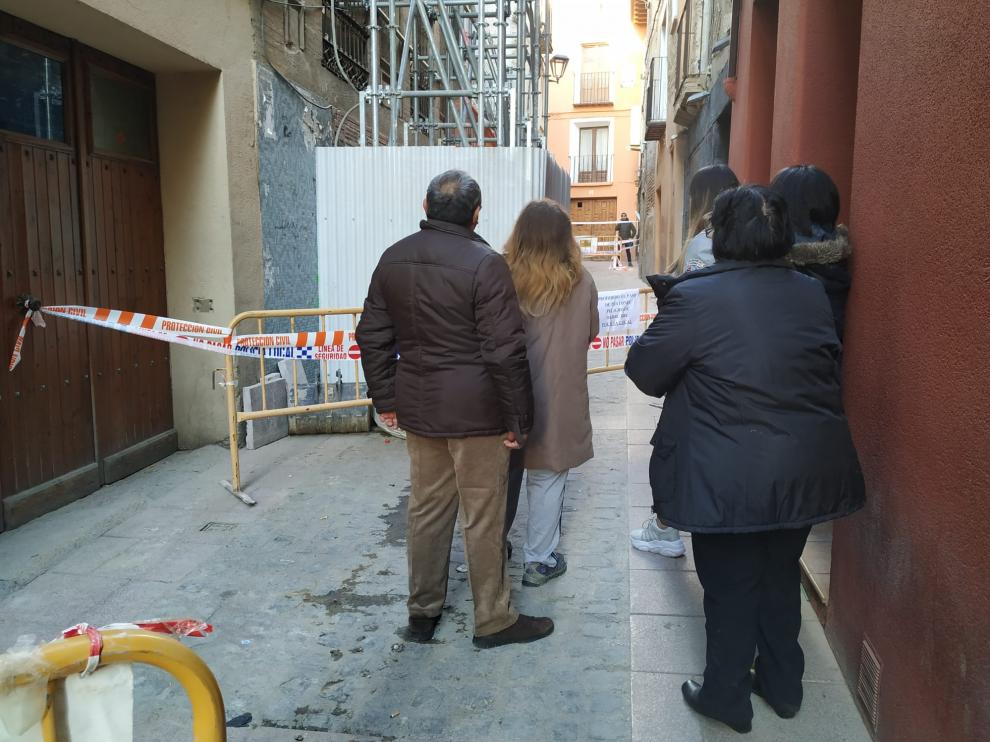La familia afectada, junto a unas sobrinas, observa su vivienda derrumbada.