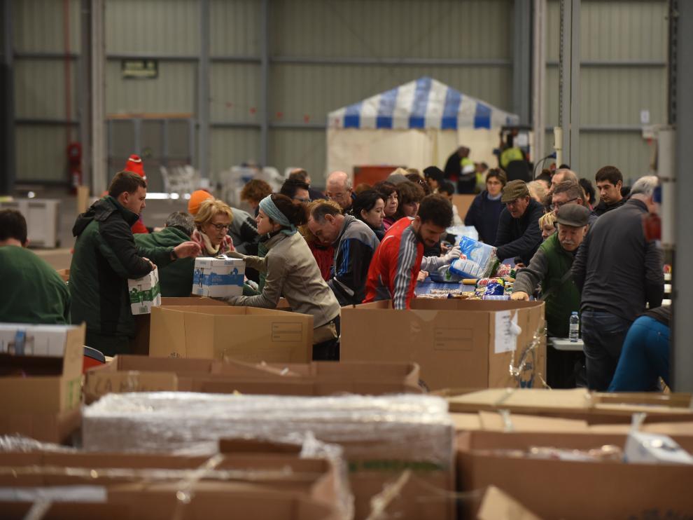 Los voluntarios clasifican todos los productos recibidos en la Feria de Muestras para trasladar después a Banco de Alimentos de Zaragoza..