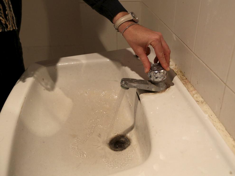 Una vecina muestra problemas de agua en Apiés, en foto de archivo.