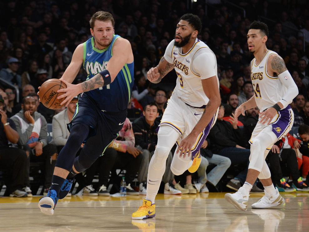 Luka Doncic supera a Anthony Davis (3) y Danny Green (14) en la victoria de Dallas Mavericks contra Los Ángeles Lakers