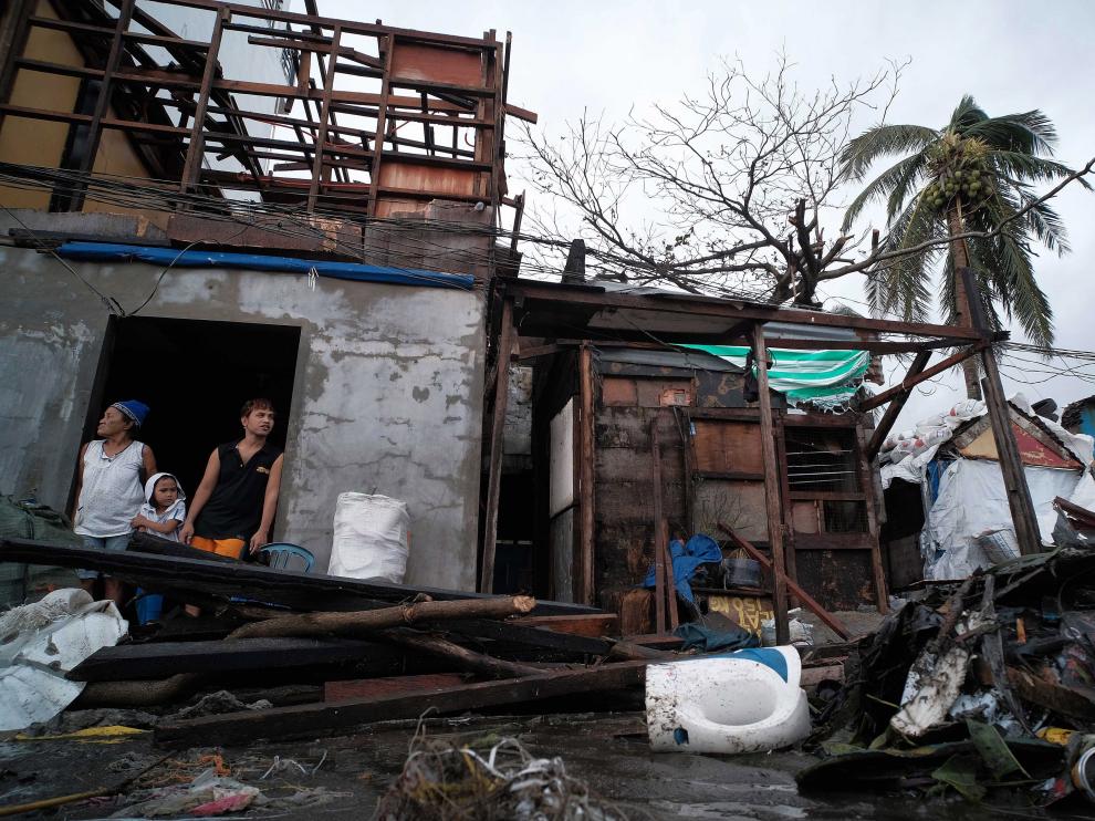 Legazpi City (Philippines), 03/12/2019.- Villagers look on from inside a damaged house in the aftermath of Typhoon Kammuri, in Legazpi city, Philippines, 03 December 2019. Typhoon Kammuri made landfall on 02 December and forced the closure of Ninoy Aquino International Airport in Manila. The typhoon also affected the ongoing Southeast Asian Games. According to the event organizers, several sporting events have been rescheduled or cancelled. (Filipinas) EFE/EPA/ZALRIAN SAYAT Aftermath of Typhoon Kammuri in the Philippines