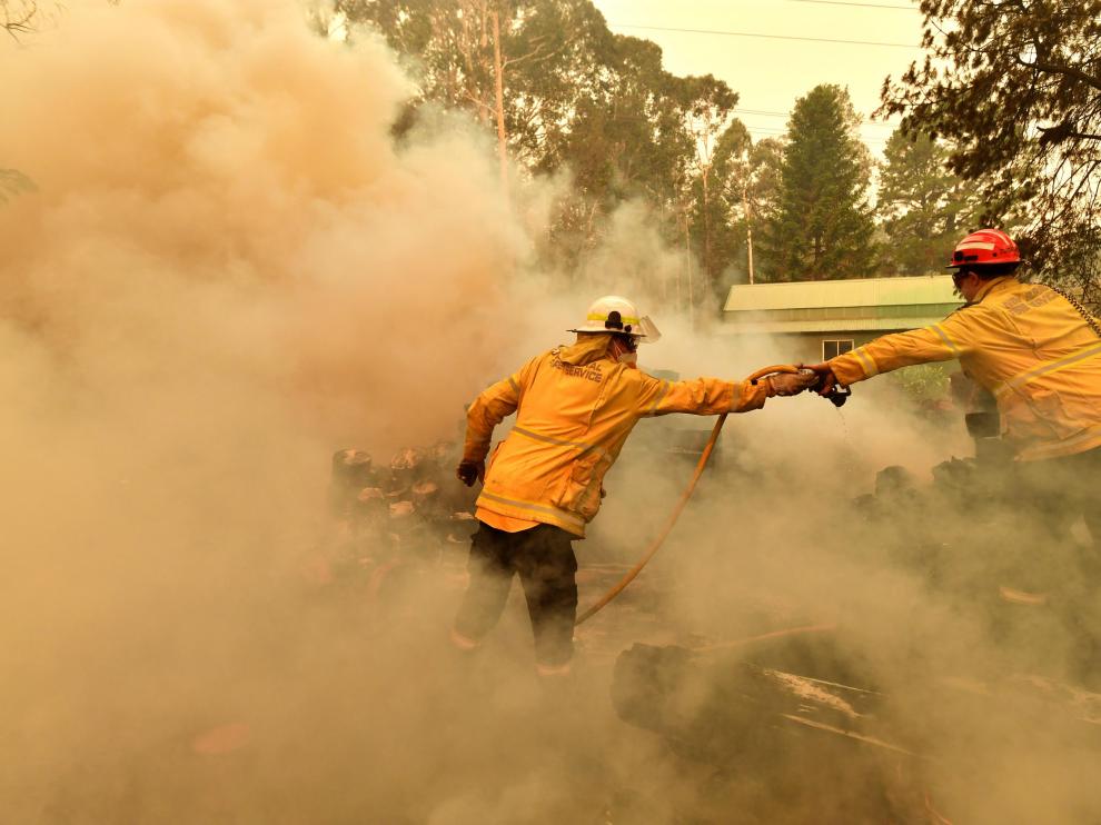 Werombi (Australia), 06/12/2019.- Firefighters hose down a burning woodpile during a bushfire in Werombi, 50km south west of Sydney, Australia, 06 December 2019. (Incendio) EFE/EPA/MICK TSIKAS AUSTRALIA AND NEW ZEALAND OUT Bushfires continue to burn in New South Wales, Australia