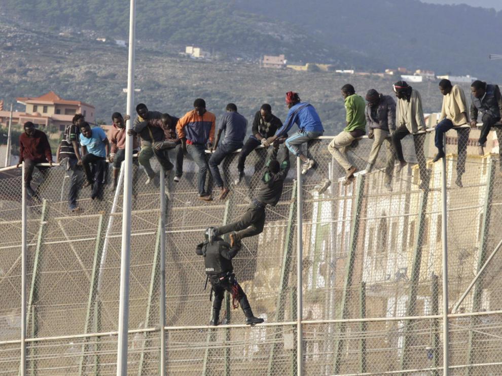 Un centenar de inmigrantes permanecen encaramados en la valla fronteriza entre Melilla y Marruecos en una imagen de archivo.