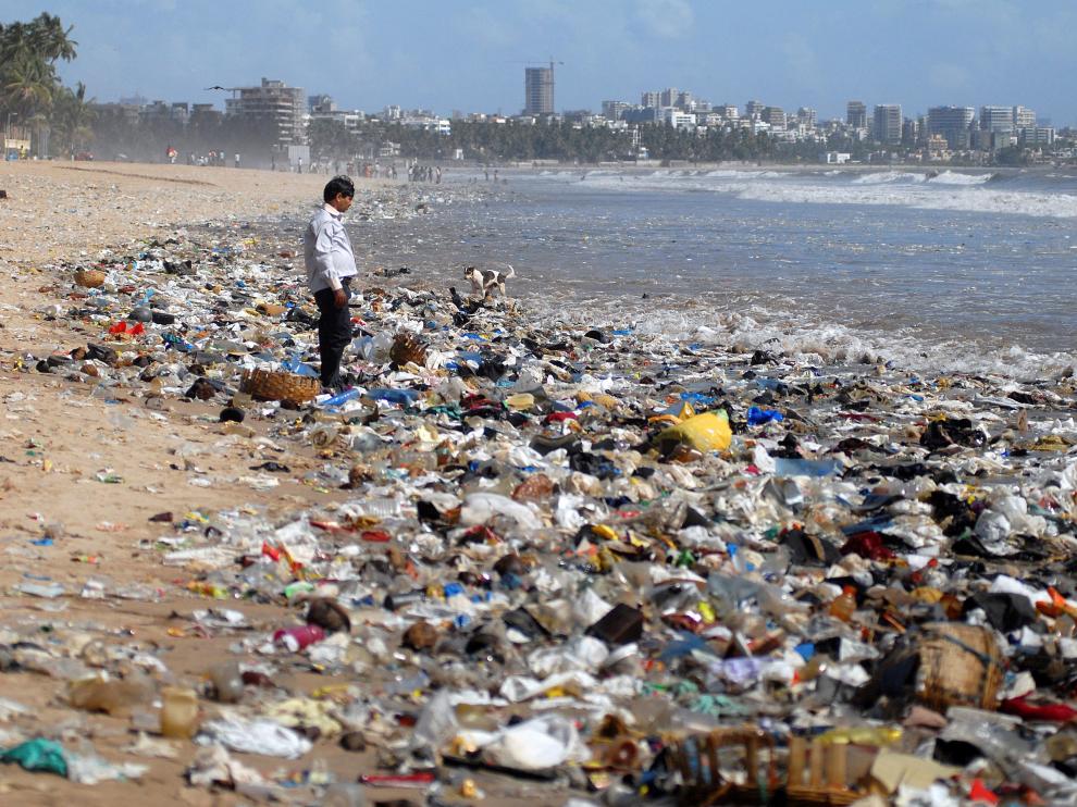 Un hombre observa una montaña de plásticos a orillas del mar Arábigo en Bombay (La India).