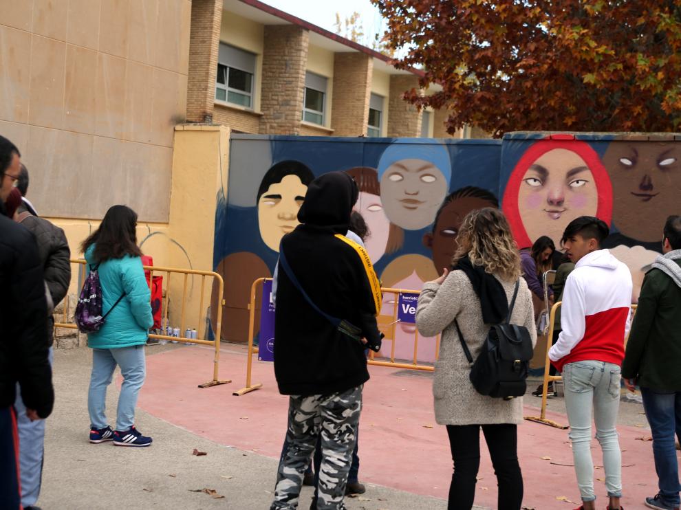 Varios vecinos contemplan una de las intervenciones artísticas llevadas a cabo en el barrio en 2018