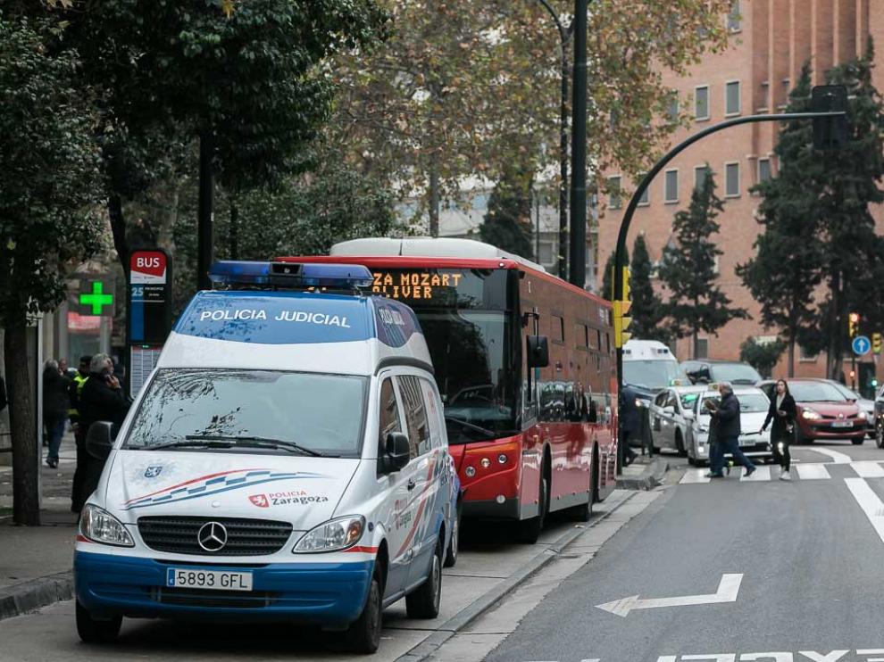 El autobús implicado en el atropello, cerca de la zona del accidente, entre dos coches de la Policía Local de Zaragoza.