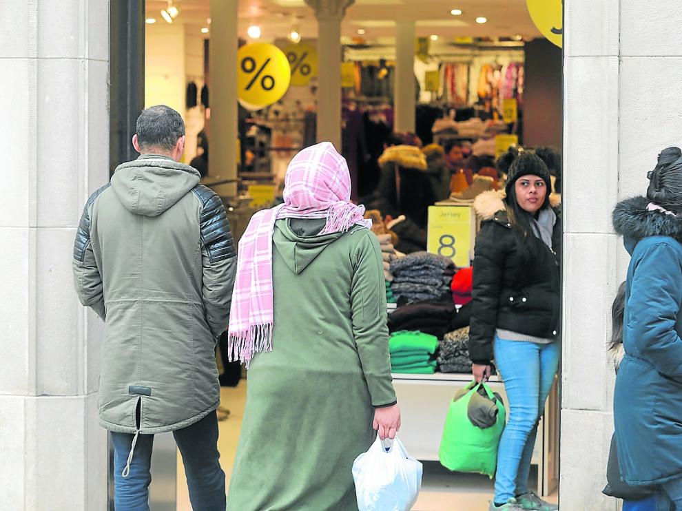 Una pareja de procedencia extranjera entrando ayer en una tienda del Coso Alto de Huesca.