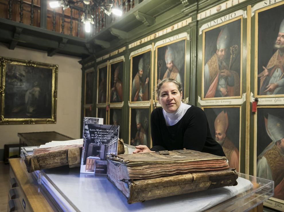 Ester Casorrán, con su libro recién publicado y documentos antiguos, en el Archivo Capitular del Pilar