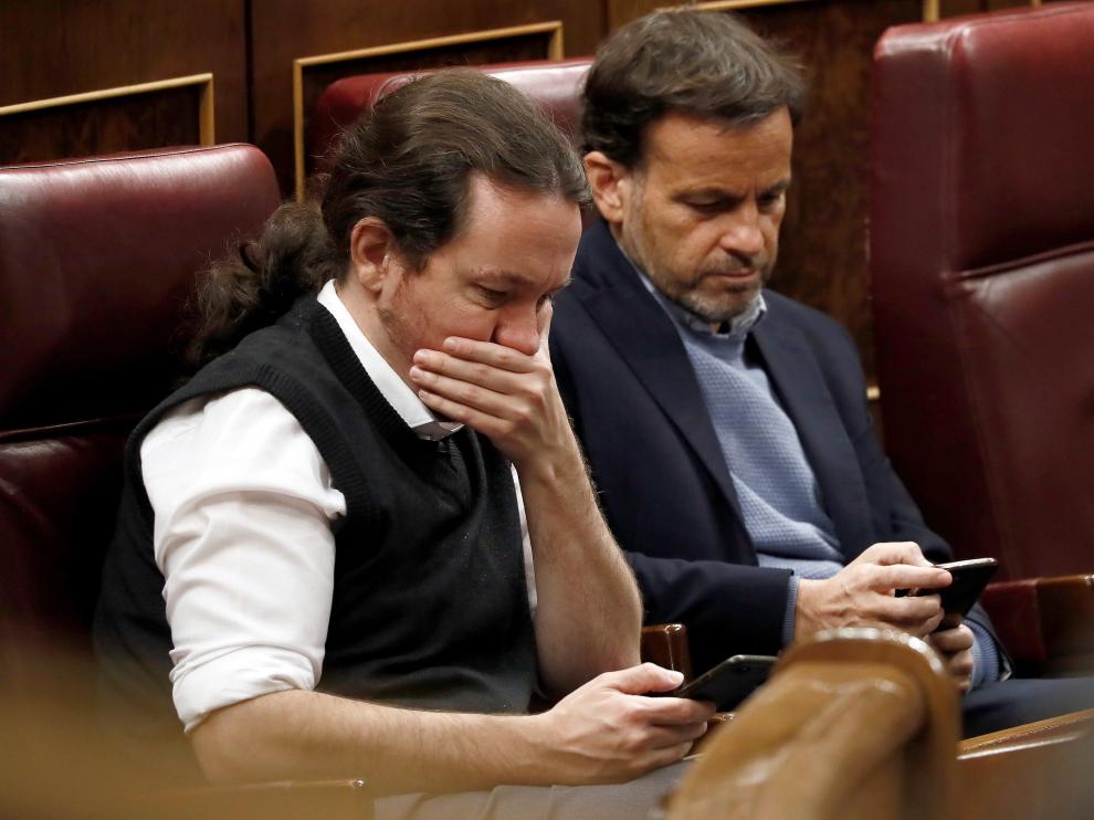 Pablo Iglesias y Jaume Asens, de Podemos, consultan el móvil en el Congreso.