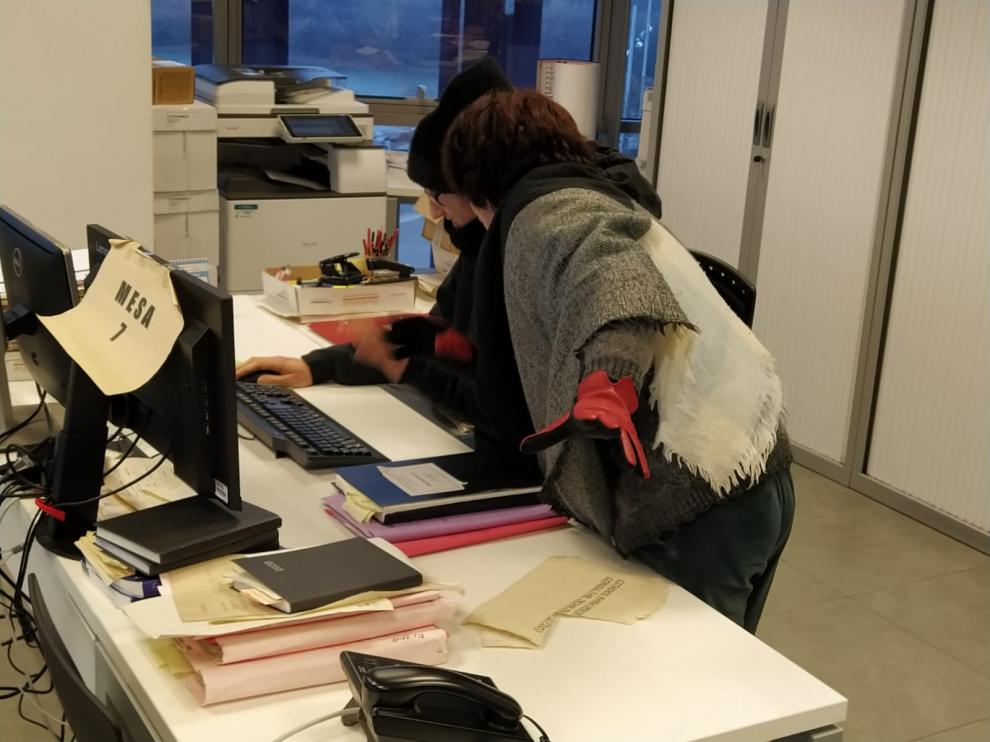 Varios funcionarios trabajando con guantes y gorros en los Juzgados de Zaragoza.