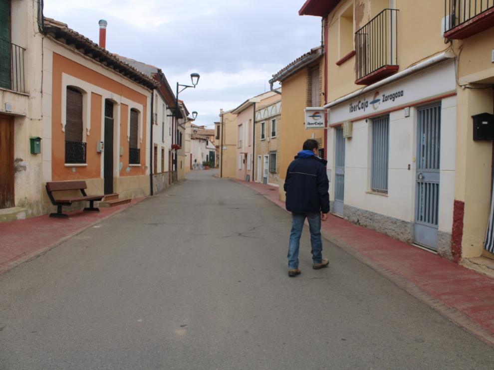 Un vecino de Torrellas pasea por delante de la oficina bancaria del pueblo