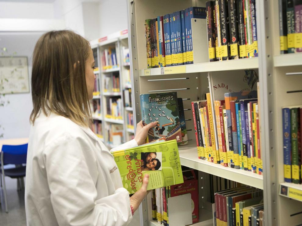 Una empleada de la Biblioteca de Aragón, en Zaragoza, ordena una estantería