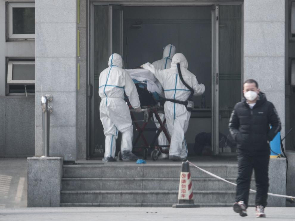 Sanitarios llevan a un paciente infectado por neumonía el sábado en la ciudad china de Wuhan.