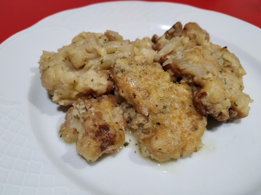 Col rebozada en harina y huevo con una picada de ajo y perejil