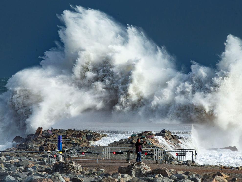 Una persona observa las impresionantes olas en la playa de Barceloneta, en Barcelona