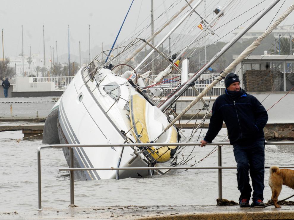 Un hombre observa las embarcaciones arrastradas por la borrasca al Port de Pollença, en Mallorca