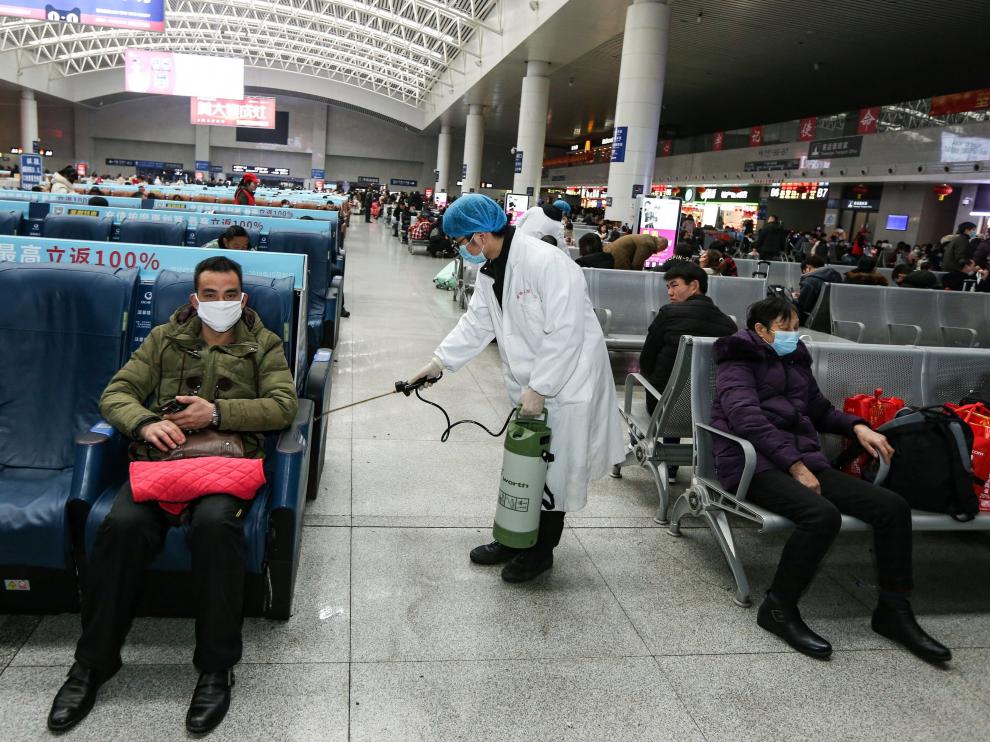 Un operario desinfecta este jueves una zona de espera para pasajeros en una estación de tren en China.