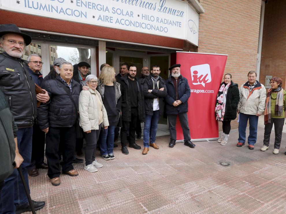 Álvaro Sanz y Antonio Camacho (con boina), junto al cartel de IU tras la asamblea.