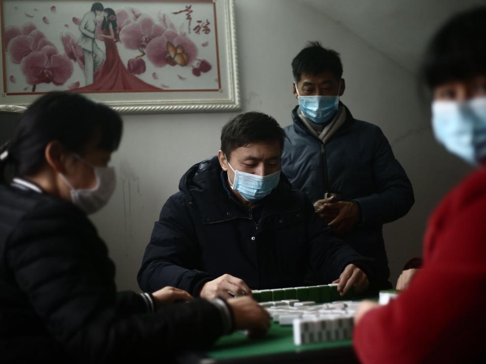 Jianli (China), 25/01/2020.- Masked family members play a board game at home in Jianli county, Hubei province, China, 25 January 2020 (issued 30 January 2020). China announced on 27 January that the Spring Festival holiday would be extended to 02 February 2020 after the coronavirus outbreak spread across the country. The virus, which originated in the Chinese city of Wuhan, has so far killed more than 160 people and infected around 6,000, mostly in China. EFE/EPA/LIU TAO CHINA OUT Spring Festival in Hubei province amid coronavirus lockdown