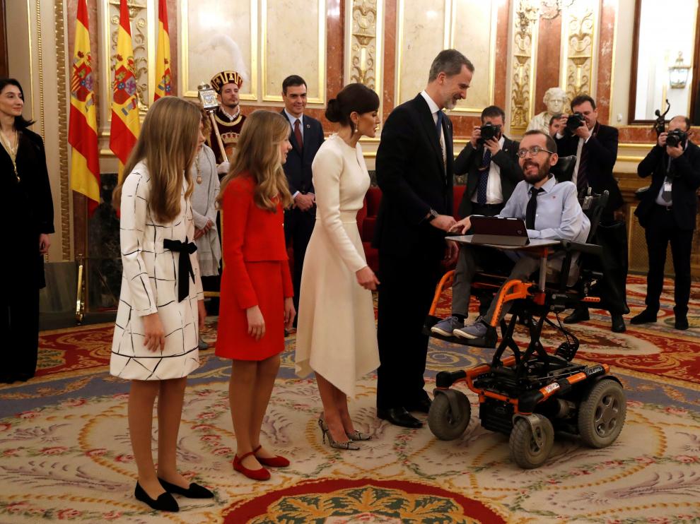 Los Reyes y sus hijas saludan al portavoz de Podemos, Pablo Echenique, en la apertura de la legislatura en el Congreso de los Diputados.